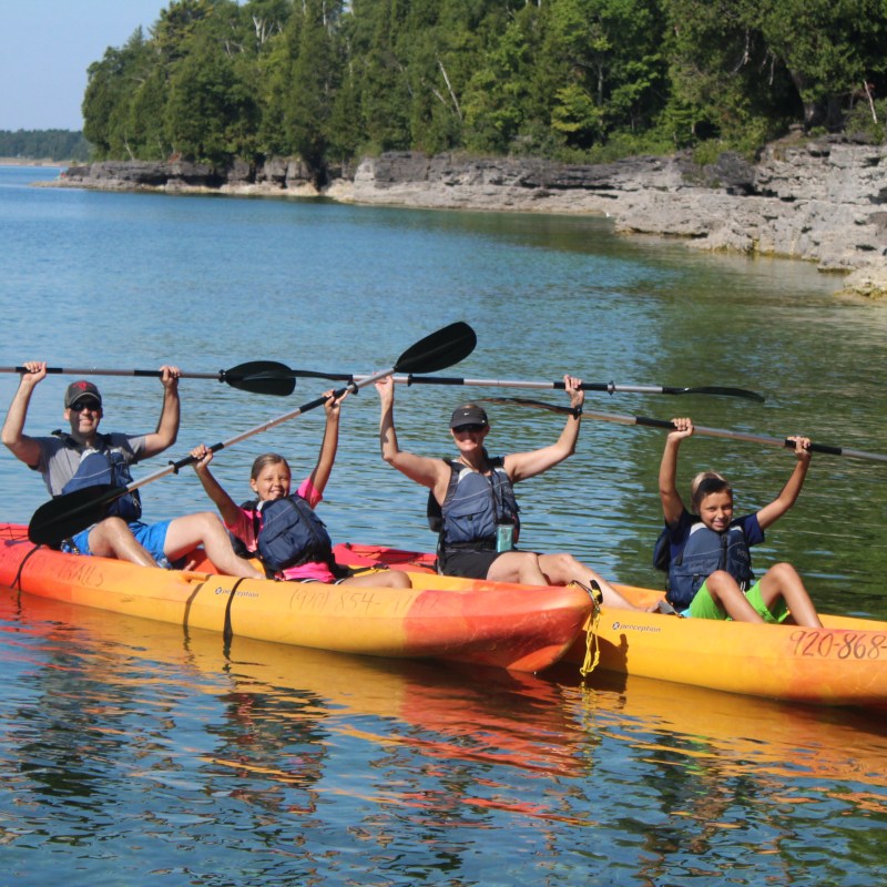 Kayakers raising their paddles with both hands on Lake Michigan