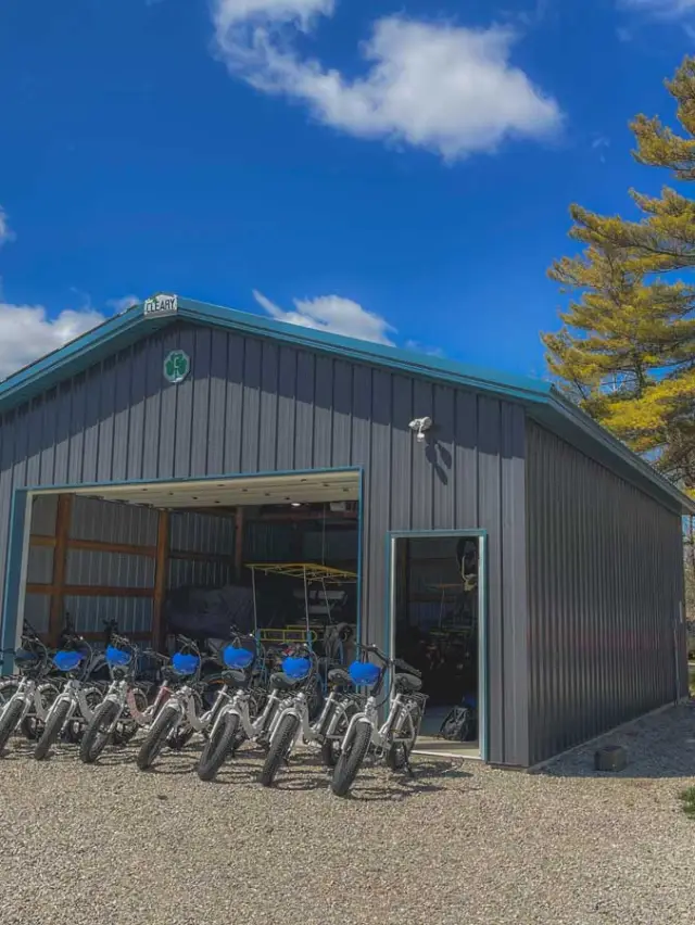 a garage with a bunch of ebikes in front of it.