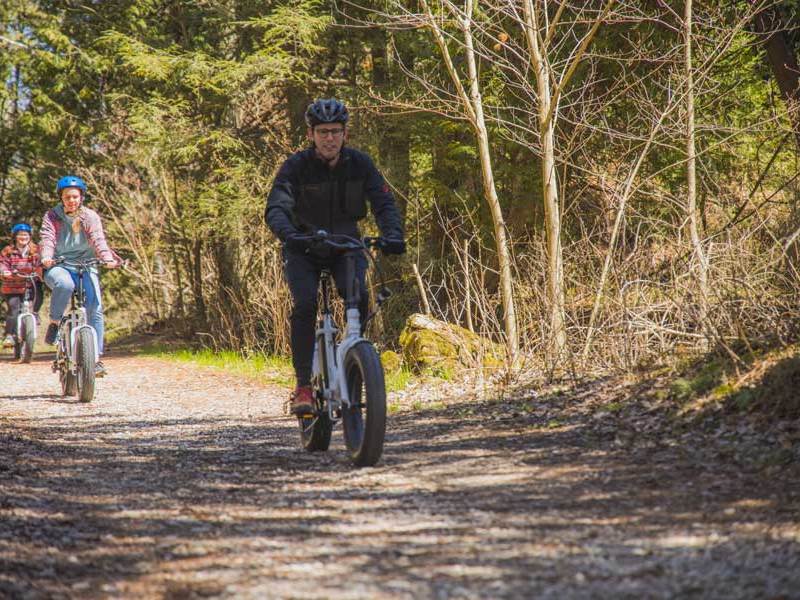 a man riding a fat tire ebike on a gravel path near whitefish bay dunes state park