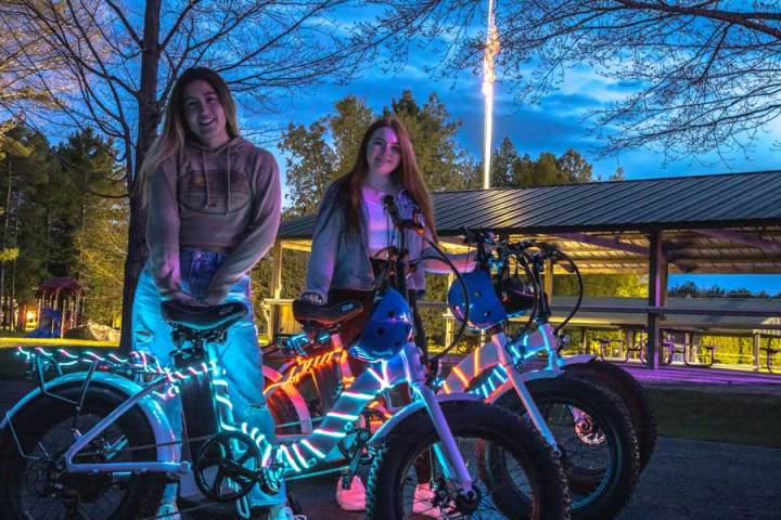 2 girls standing near e-bikes
