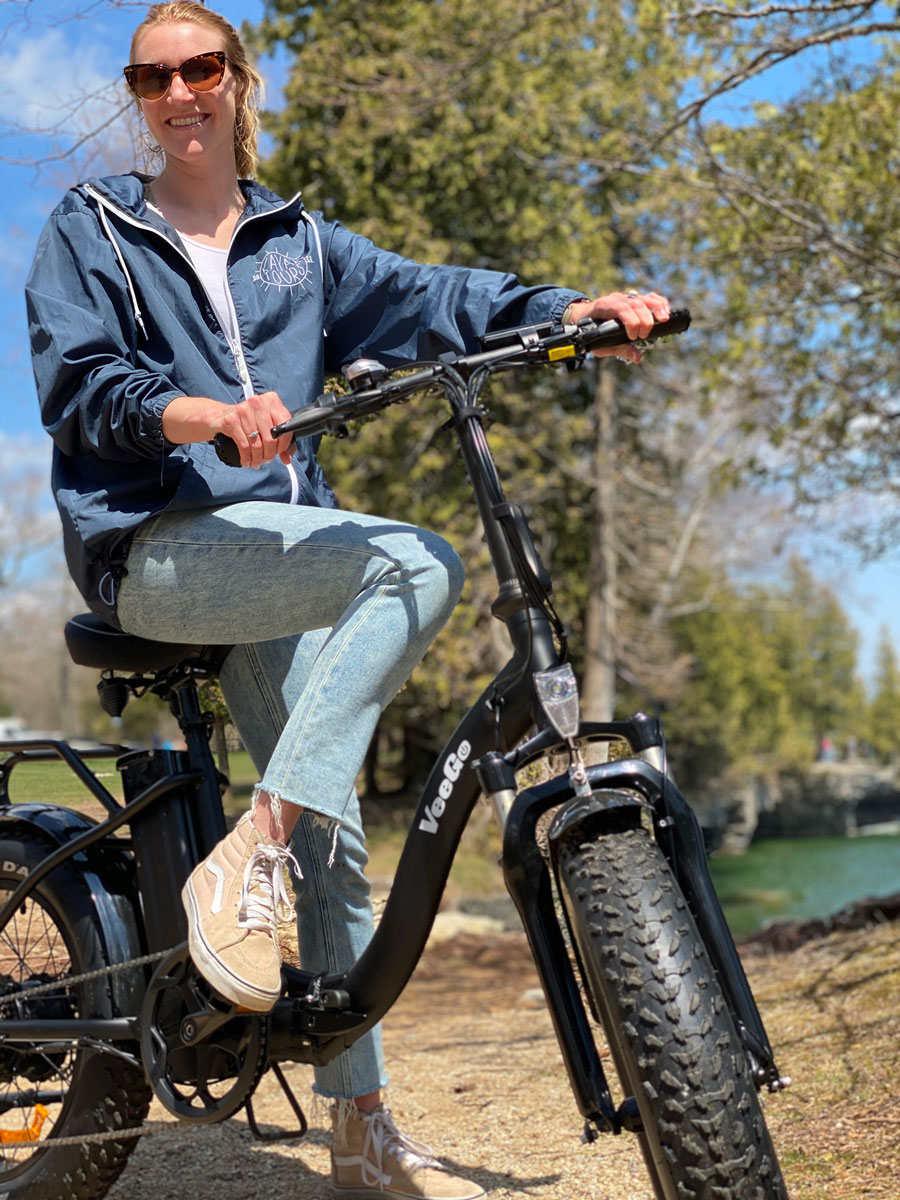 a person wearing a helmet and holding a bicycle