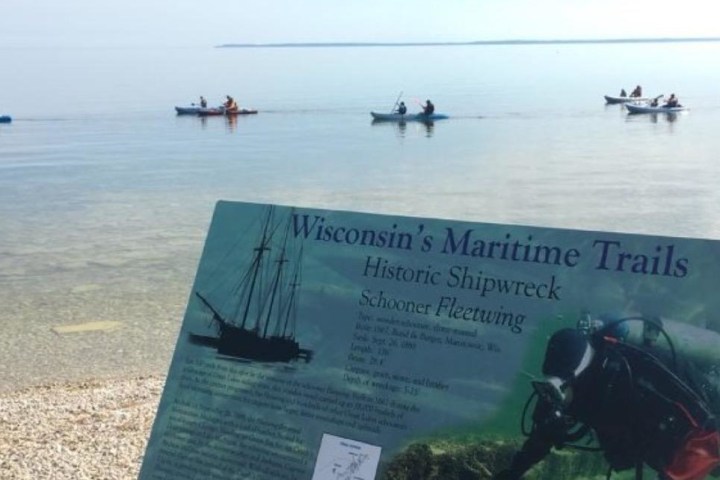 a group of people sitting on a boat in the water