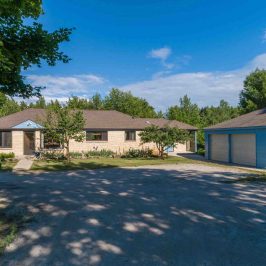 a dirt road in front of a house