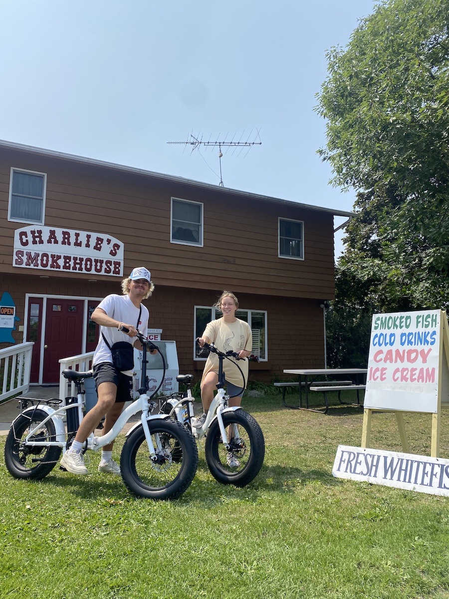 a group of people standing around a motorcycle in front of a house