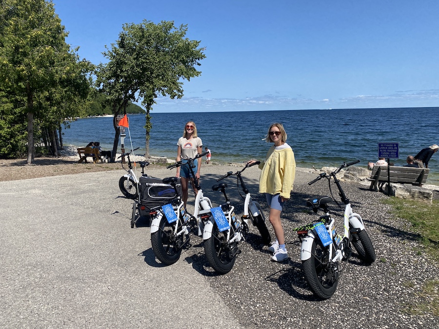 a group of people sitting on a motorcycle on a beach