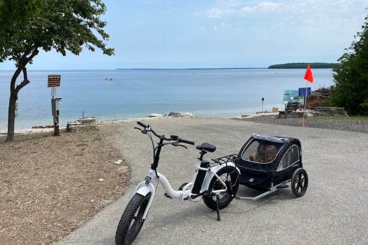 a motorcycle parked on a beach in front of a body of water