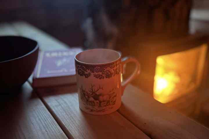 a cup of coffee sitting on top of a wooden table